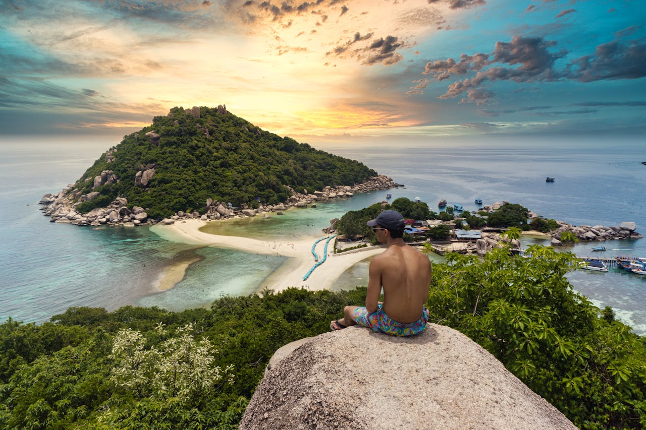 Man admiring breathtaking sunset view of Koh Nang Yuan Island in Thailand.